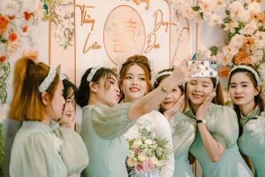 A joyful bride and bridesmaids capturing a selfie during a wedding celebration, surrounded by floral decor.